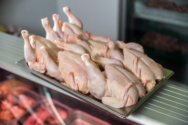 Raw whole chicken on iron tray