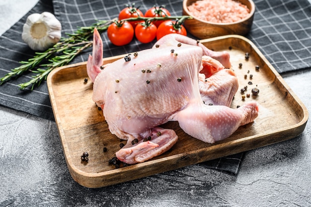 Raw whole chicken with spices and seasonings. Top view