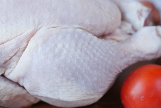 raw whole chicken on wooden background