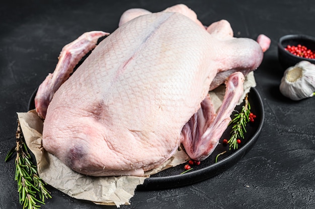 Raw whole duck, pink pepper and rosemary