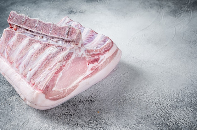 Raw whole rack of pork loin with ribs on kitchen table.