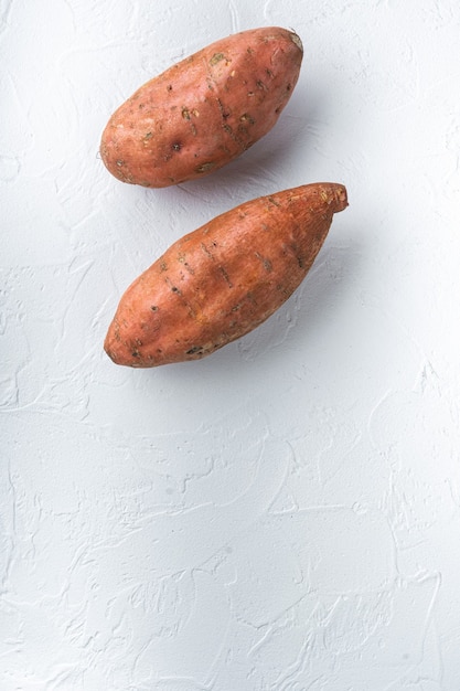 Raw whole sweet potatoe on white background, flat lay with copyspace.