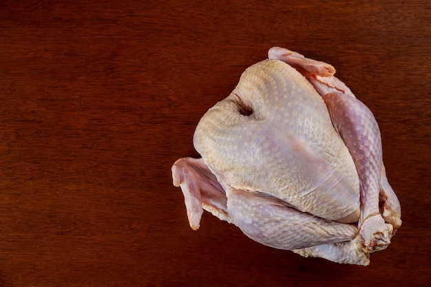 Raw whole turkey isolated on wooden background.