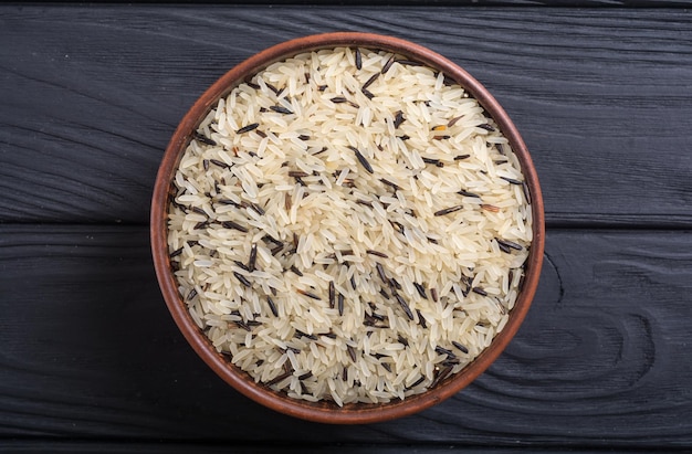Photo raw wild rice white and black food on rustic background
