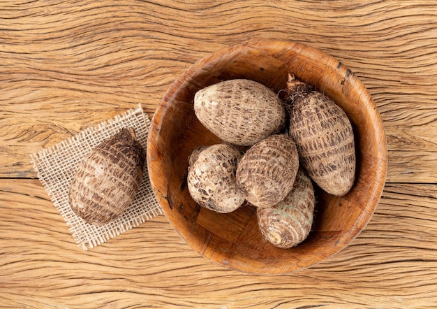 Raw yams or inhames on a bowl over wooden table with copy space