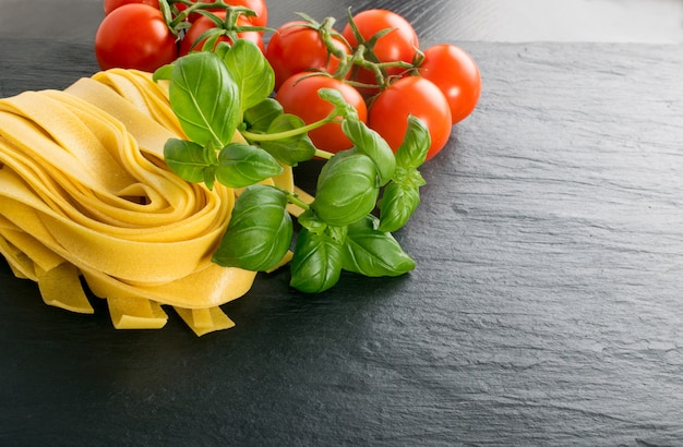 Raw yellow italian pasta pappardelle, fettuccine or tagliatelle close up.