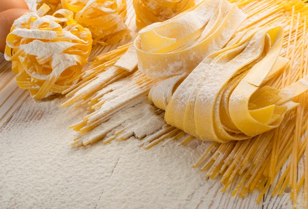 Raw yellow italian pasta pappardelle, fettuccine or tagliatelle