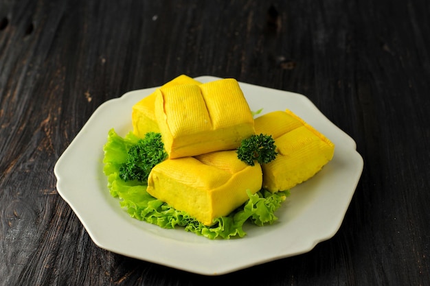 Il tofu giallo crudo (tahu kuning - indonesia) è un alimento tradizionale di bandung, in indonesia. è fatto con semi di soia, pronto da cuocere, fritto, al vapore o saltato in padella.