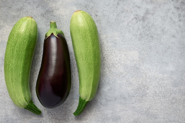 生のズッキーニと紫のナス。コピースペース、有機野菜と灰色の背景