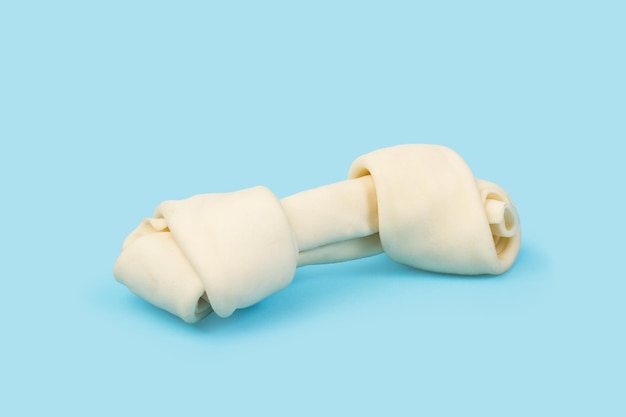 A rawhide bone on a light blue background