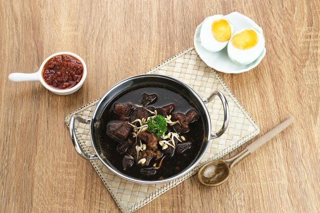 Rawon Indonesian Traditional beef black soup Served on a bowl with mung bean sprouts chilli paste