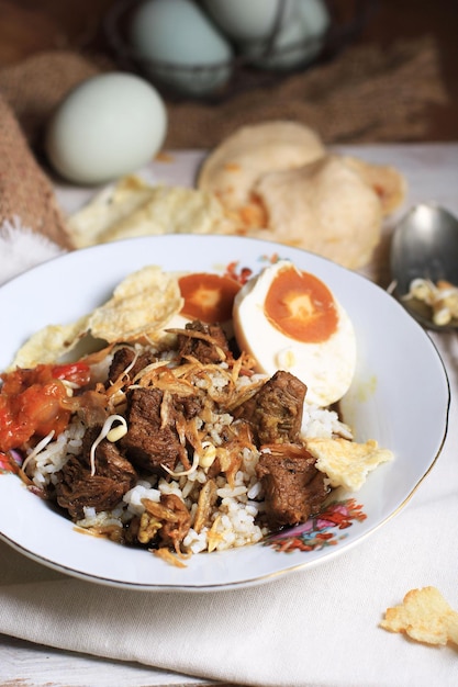 Rawon of Nasi Rawon Rawon Rice is een sterk, rijk smakende traditionele Indonesische zwarte rundvleessoep geserveerd met spruitjes kludek kruiden Uit oost java