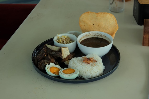 Rawon rice or beef black soup on round plate