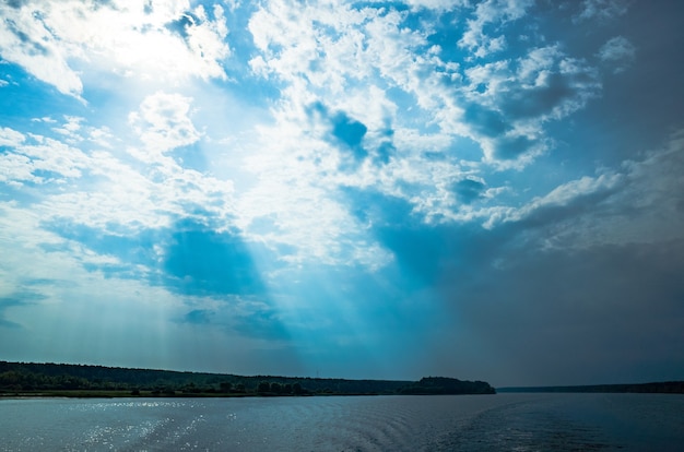 강 풍경에서 신의 광선 태양 광선은 물 복사 공간에 구름을 통해 빛난다