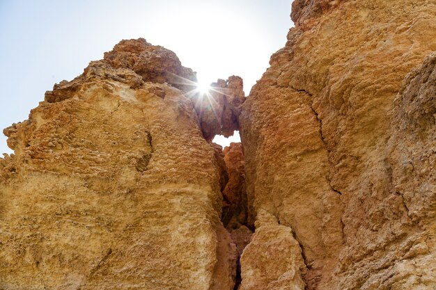 The rays of the sun shining through rocks on a sunny summer day.