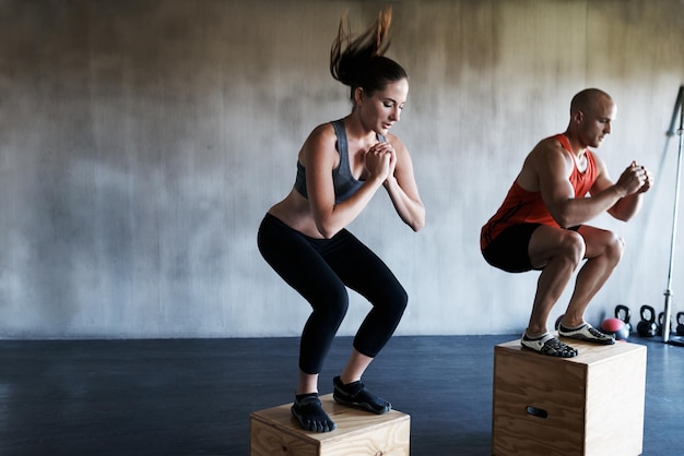 Raggiungi la tua modalità bestia. inquadratura di un uomo e una donna che si allenano insieme in palestra.