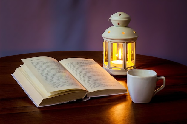 read the book in the light of a lantern with a cup of coffee or tea