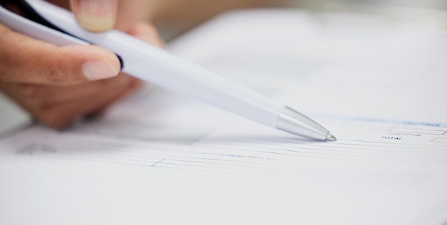 Photo read carefully. shot of an unrecognizable woman filling in a form on a desk in an office.