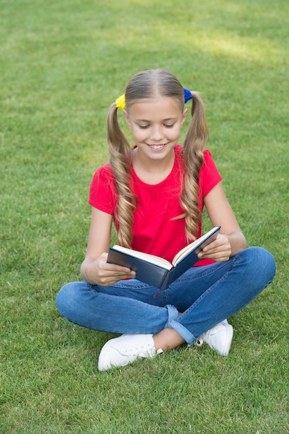 For reading addicts. Happy child read book on green grass. Little girl enjoy reading summer outdoors. Summer reading list. Developing imagination. Reading is breathing for mind.