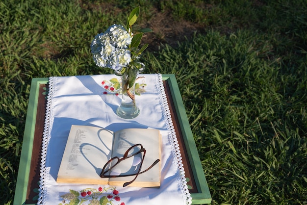 Photo reading a book in the park is a pleasure of calmness concept table
