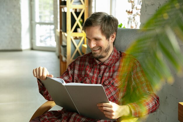 Reading book on sofa. caucasian man staying at home during quarantine