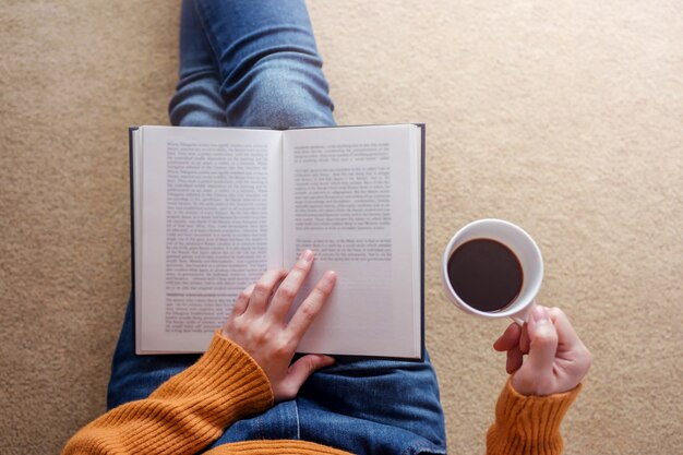 Reading Concept. Soft Focus of  Young Woman Relaxing by Book and Coffee in Cozy House