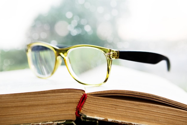 Reading glasses and book on rainy window