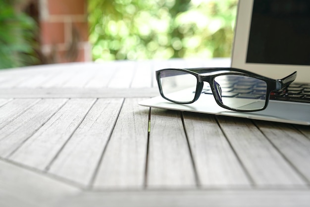 Reading glasses on top of computer laptop with copy space