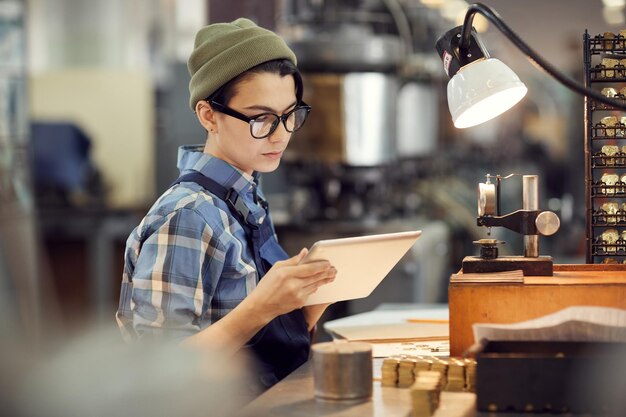 Reading instruction on tablet at assembly shop