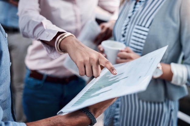 Reading into the latest reports Closeup shot of a group of unrecognizable businesspeople analyzing graphs outdoors