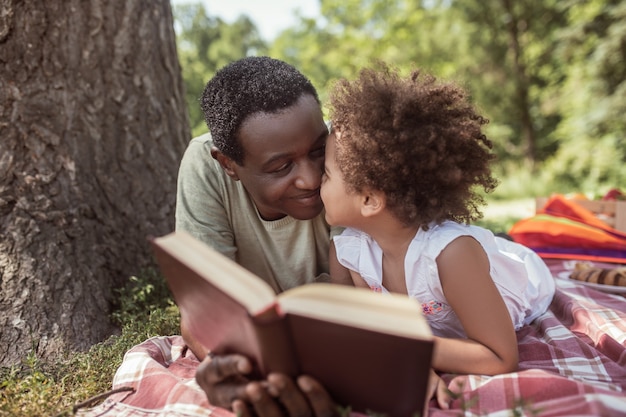 Reading.  man and his cute kid reading a book together