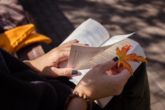 Reading a paper book. turn pages. reading in the park. they\
will have a rest on the day off. autumn