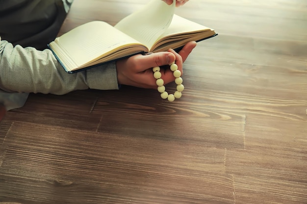 Foto leggere la letteratura religiosa un uomo studia il corano e ordina il rosario