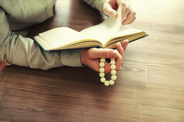 Reading religious literature A man studies the Koran and sorts out the rosary