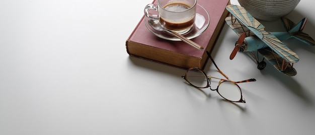 Фото Стол для чтения с копией пространства, книга, очки, чашка кофе и украшения на столе