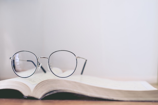 Photo reading thin frame glasses on book