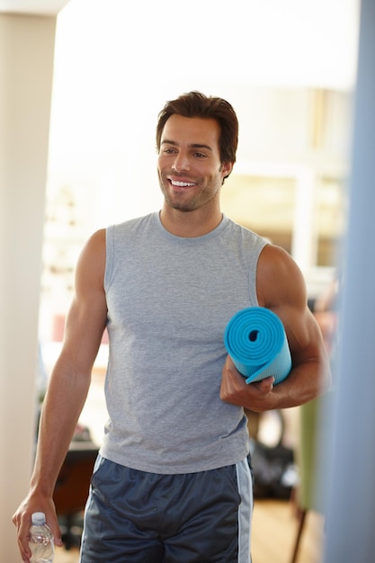 Ready to challenge myself on the mat Shot of a handsome young man in sports wear on his way to yoga