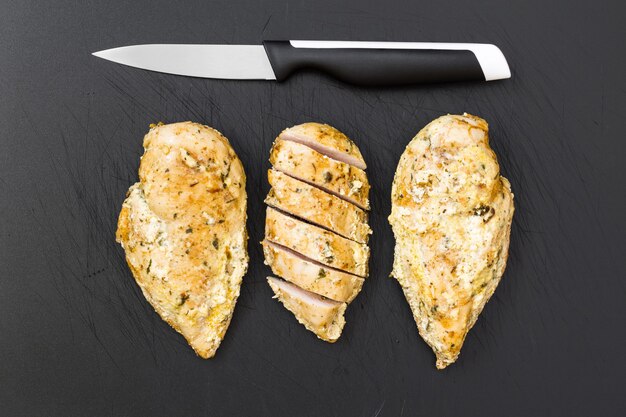 Pollo pronto sul vecchio tagliere di plastica.