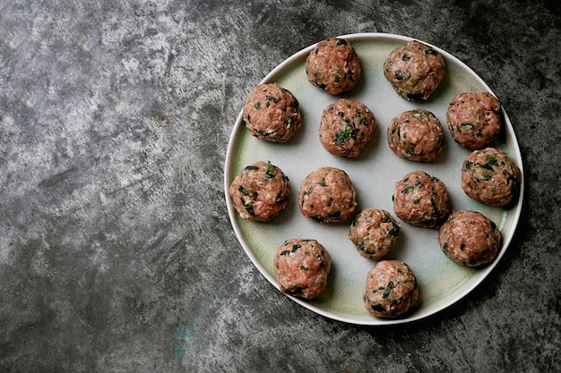 Ready to cook meatballs in ceramic plate. flat lay. top view