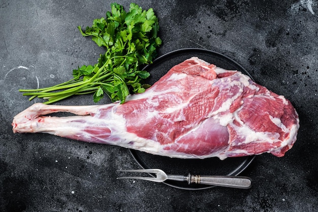 Ready for cooking raw lamb mutton leg with Thigh Black background Top view