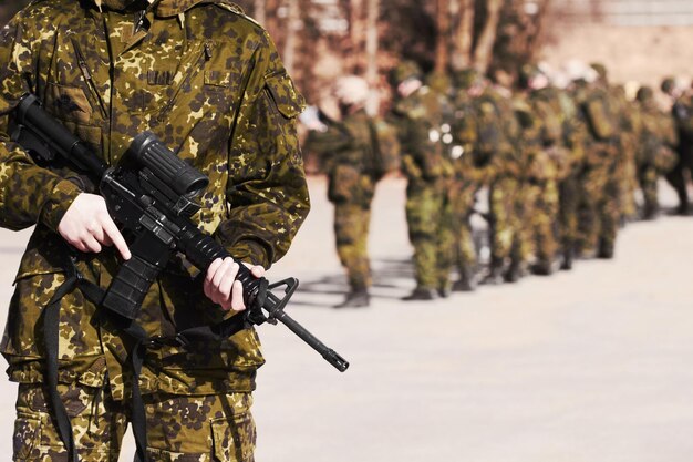 Ready for everything A soldier standing with a rifle and his fellow soldiers in the background