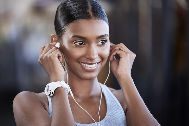 Ready to get started on the best workout today Shot of a sporty young woman listening to music while exercising in a gym