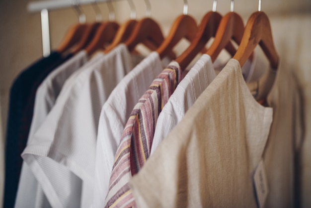 Ready-made dresses of light shades hang on hangers.