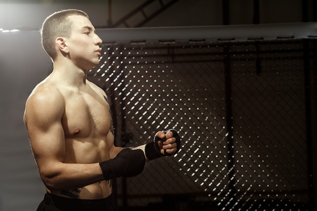 Ready for some pain? Half length portrait of a young fit male fighter in a fighting cage