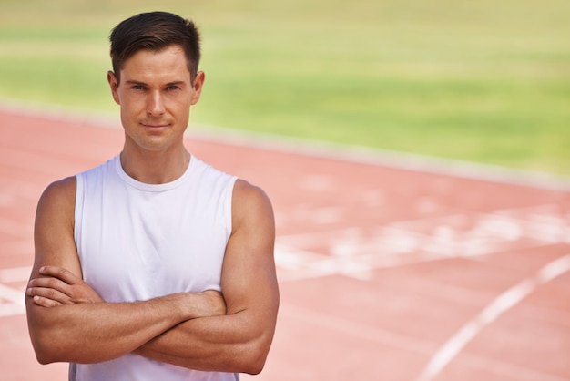 Foto pronto a portarti su ritratto di un atleta dall'aspetto determinato in piedi sulla pista