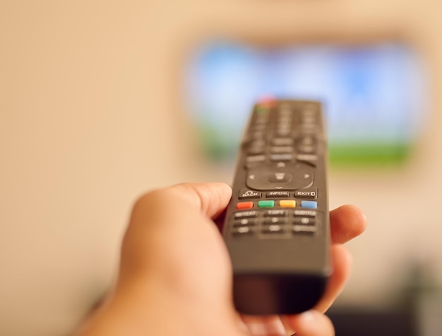 写真 フラットスクリーンテレビでリモコンを狙っている人のメロドラママラソンpovショットを開始する準備ができました