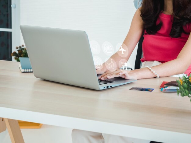 Pronto per il viaggio e il concetto di piano per le vacanze prenotazione riuscita con icone biglietto aereo hotel luogo per lo shopping cambio di denaro e ristorante a portata di mano utilizzando il computer portatile a casa per le prossime vacanze