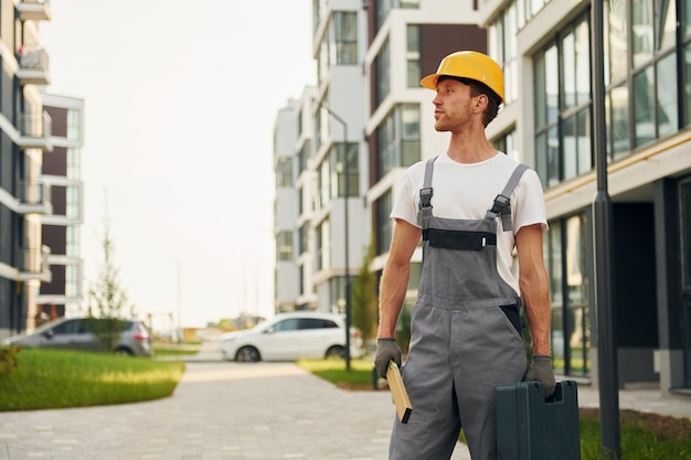 仕事の準備ができて昼間の建設で制服を着た若い男