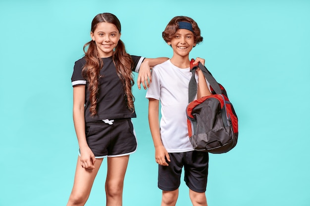 Ready for workout two happy teenagers boy and girl in sportswear looking at camera and smiling