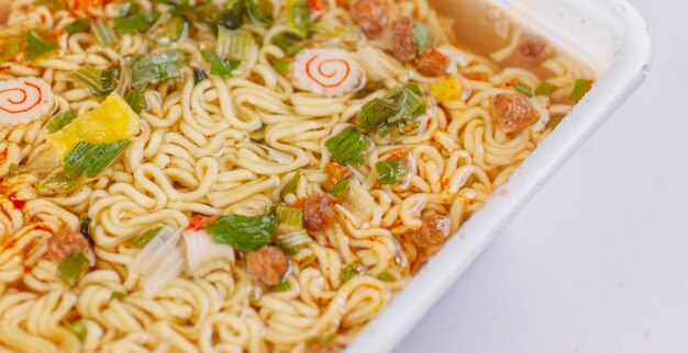 Readymade instant noodles with spices and condiments in styrofoam packaging cooked instant soup concept of fast convenient nutritious